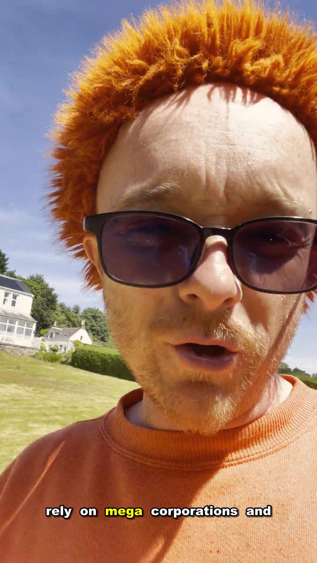 A vertical still from Gingerbeard’s Arran dispatch, filmed outside in bright sun with an orange hat and dark glasses.